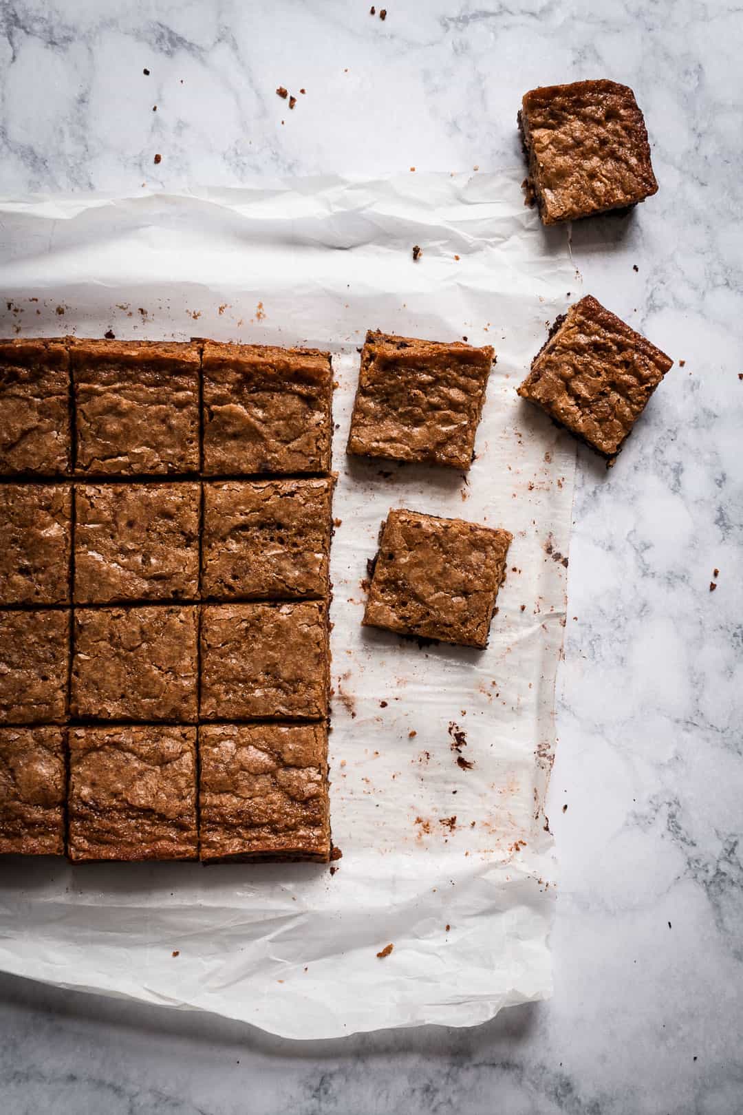 butterscotch dark chocolate bars on parchment paper cooling on a marble countertop