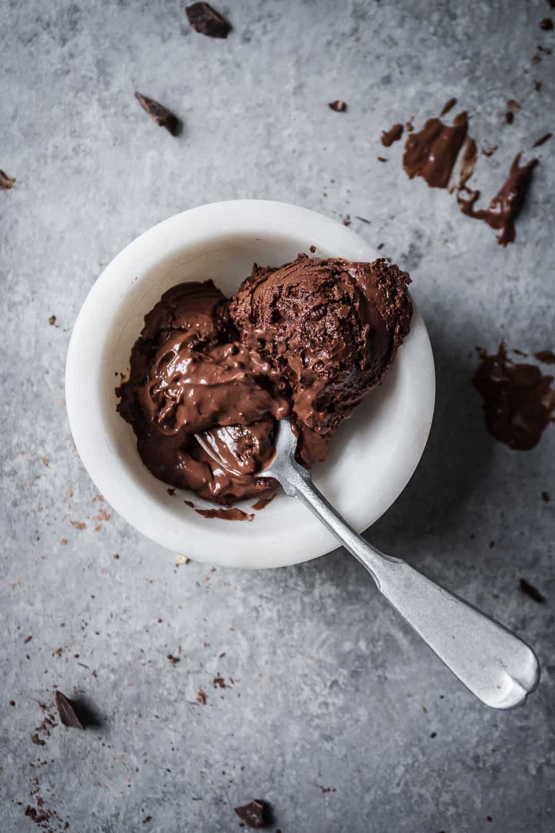 top view of small white bowl with a scoop of mint mocha chocolate chip ice cream and a silver spoon