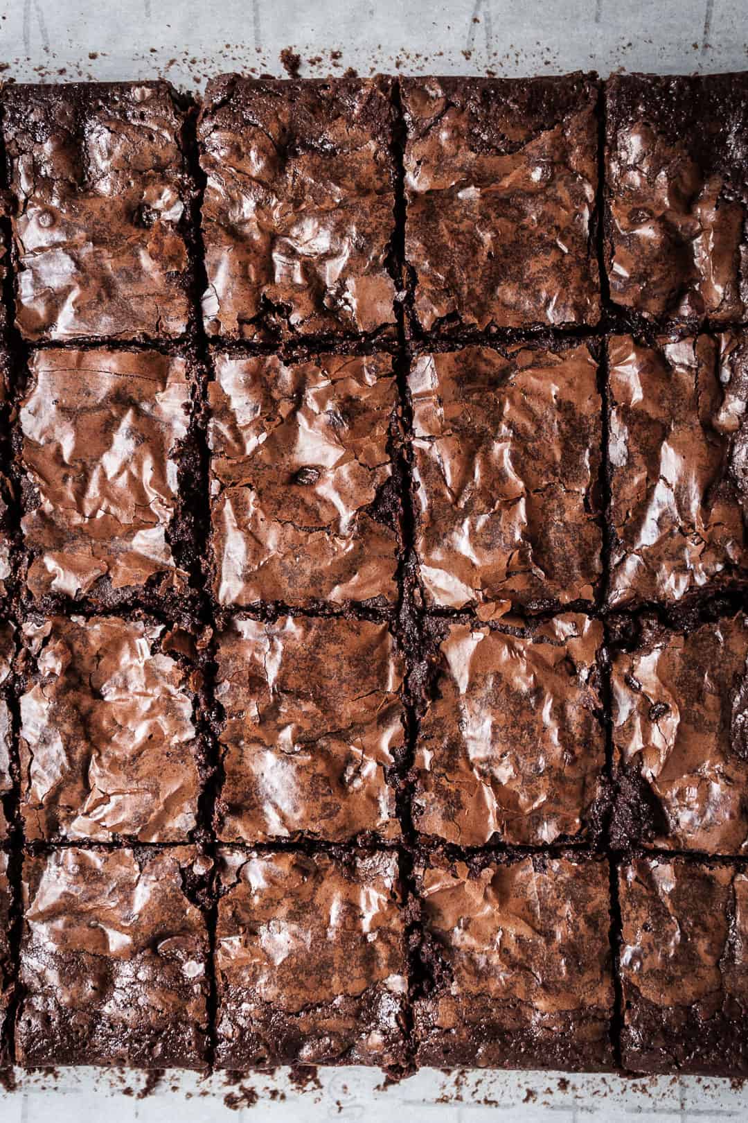Top view close up of a grid of cut squares of brownies with port soaked cherries