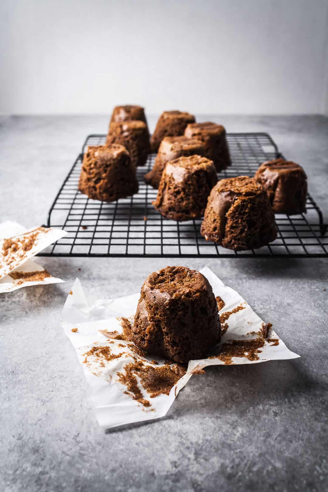 Apple ginger mini cake on parchment paper with more cakes on a rack in the background