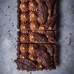Top view of Salted Caramel Chocolate Tart with Whipped Ganache with slices cut into it