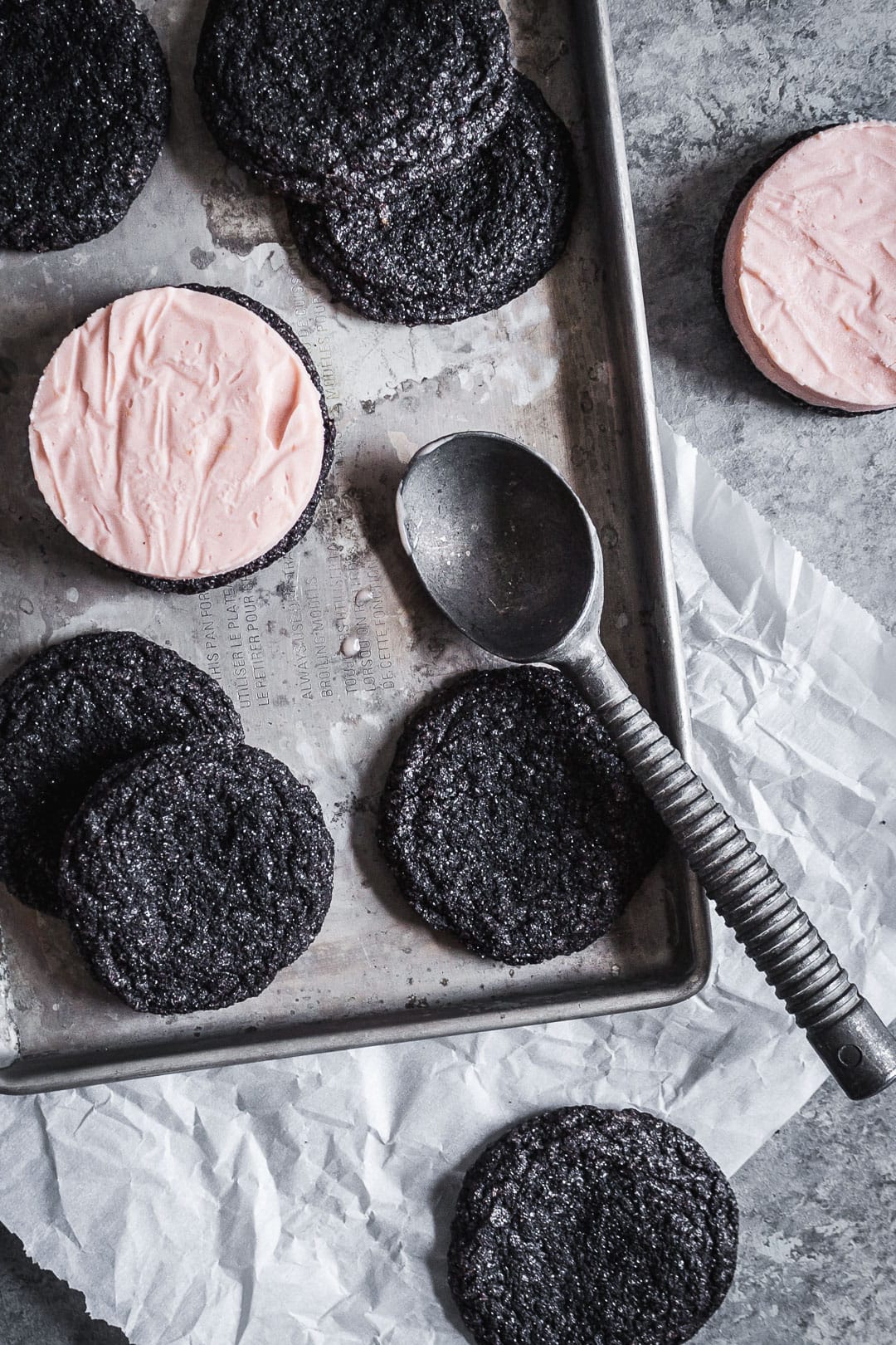 Ice cream sandwiches being built - cookies with circle of blood orange ice cream on top