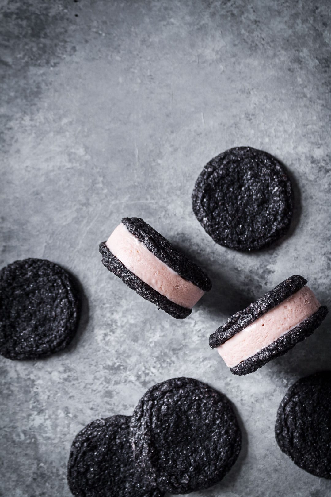 Top view of chocolate blood orange ice cream sandwiches surrounded by additional sandwich cookies