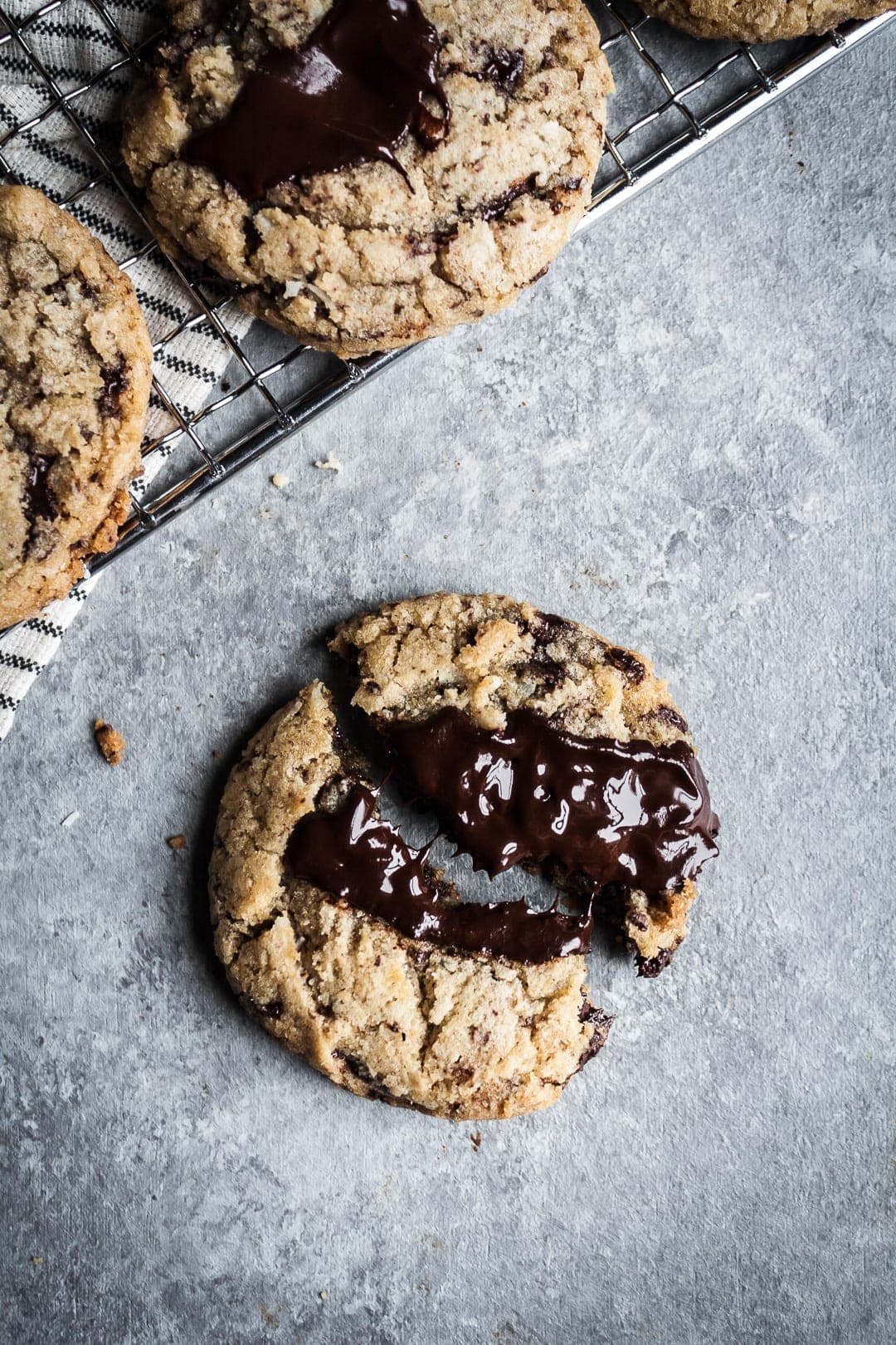 Close up of a freshly baked cookie broken in half to show the melting strings of chocolate