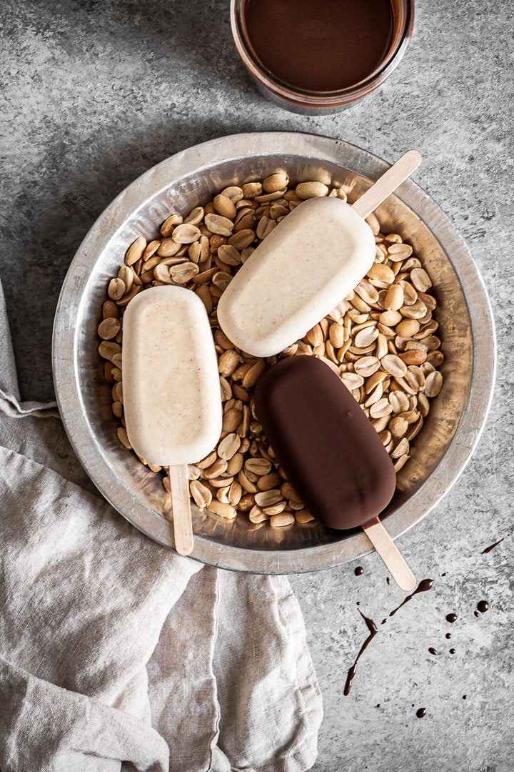 Ice cream bars in a tray filled with peanuts