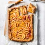 Top view of baked galette with slices cut out on a white marble background
