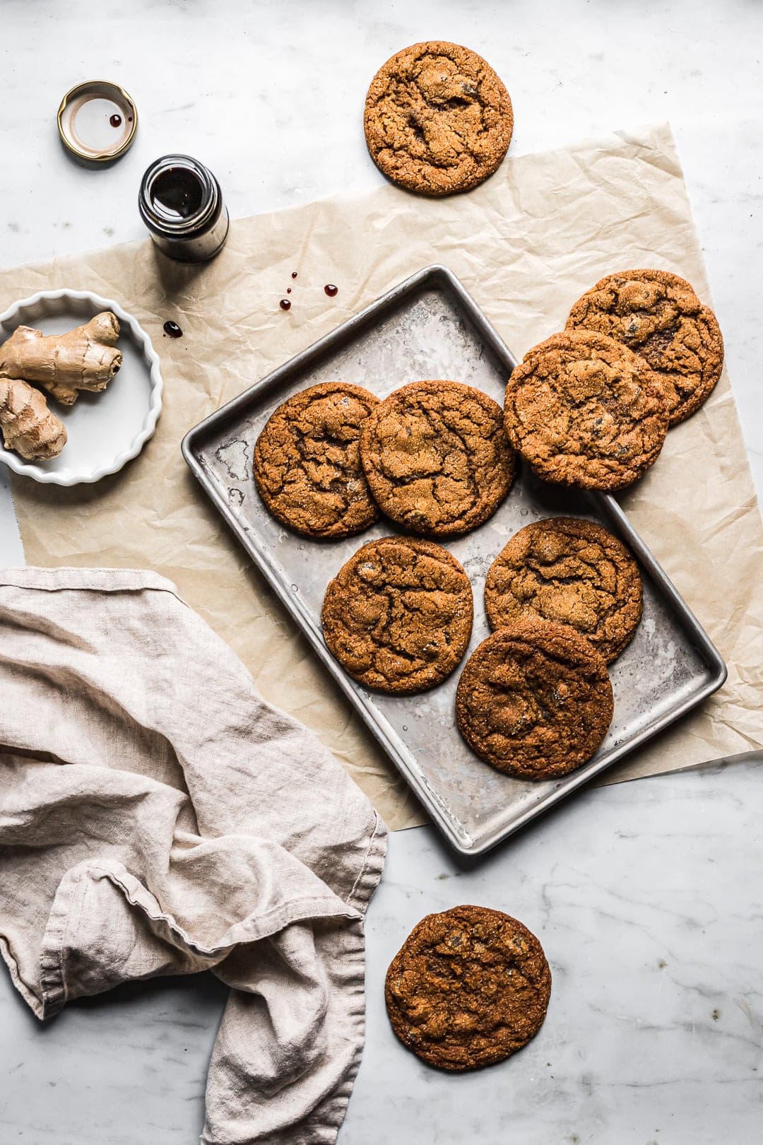 Cookies on metal pan layered on natural parchment and white marble