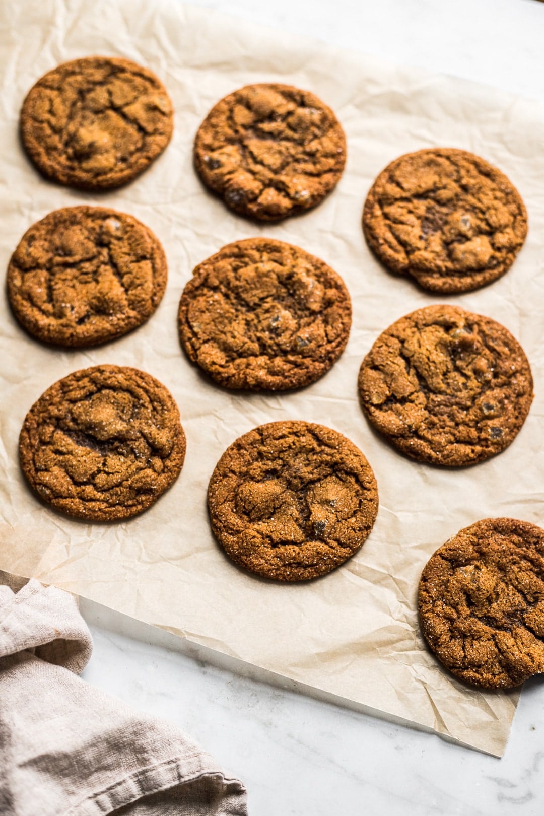 Cookies on natural parchment paper on white marble background