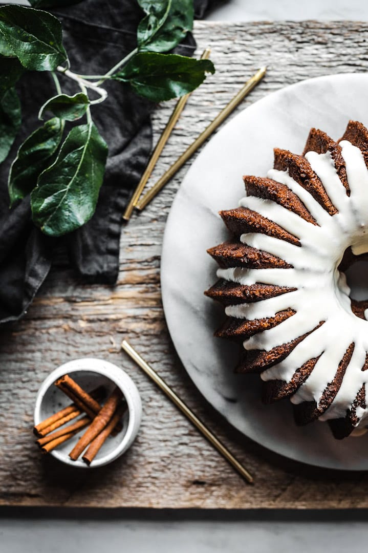 Top view of bundt cake with vanilla glaze on marble platter