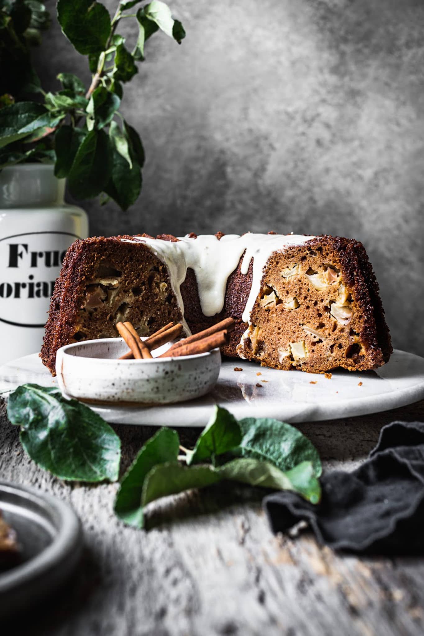 Side view of cut apple bundt cake with grey background