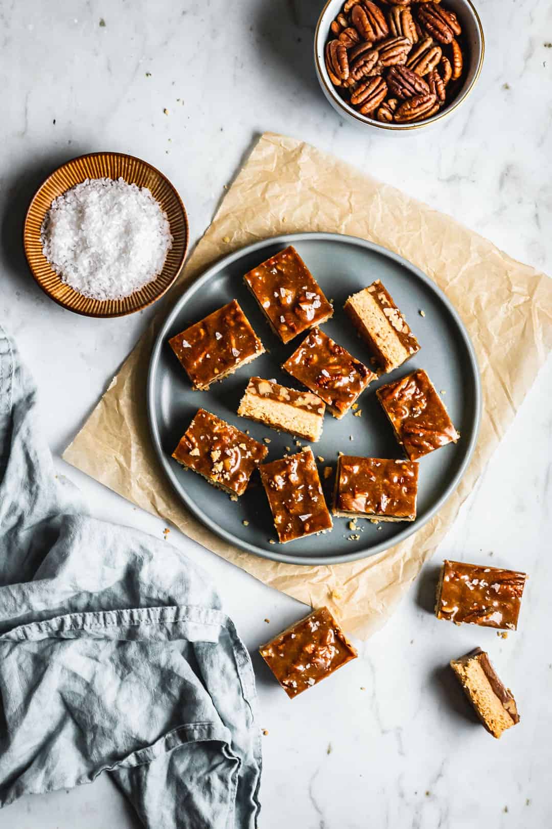 Flat lay of bar cookies on a blue plate and marble surface