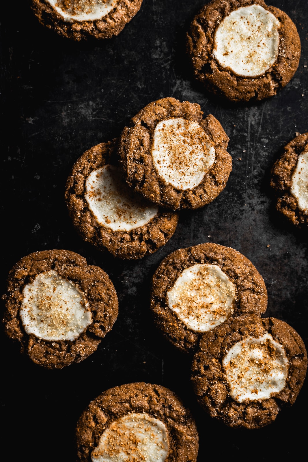 pumpkin thumbprint cookies on a dark cookie sheet background