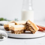 Sliced bars on a white plate with carrots and a jug of milk in the background