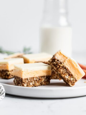 Sliced bars on a white plate with carrots and a jug of milk in the background