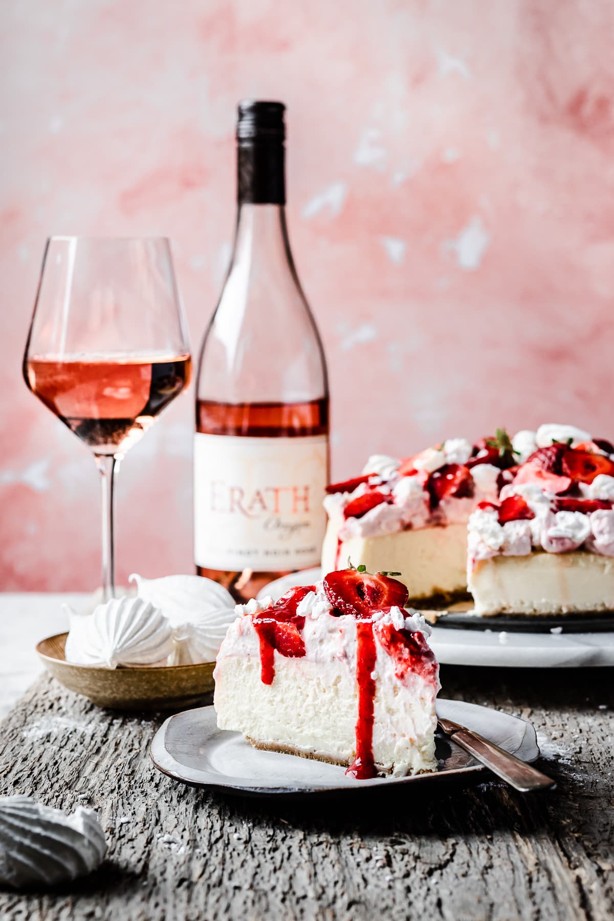 A strawberry topped cheesecake slice on a plate.