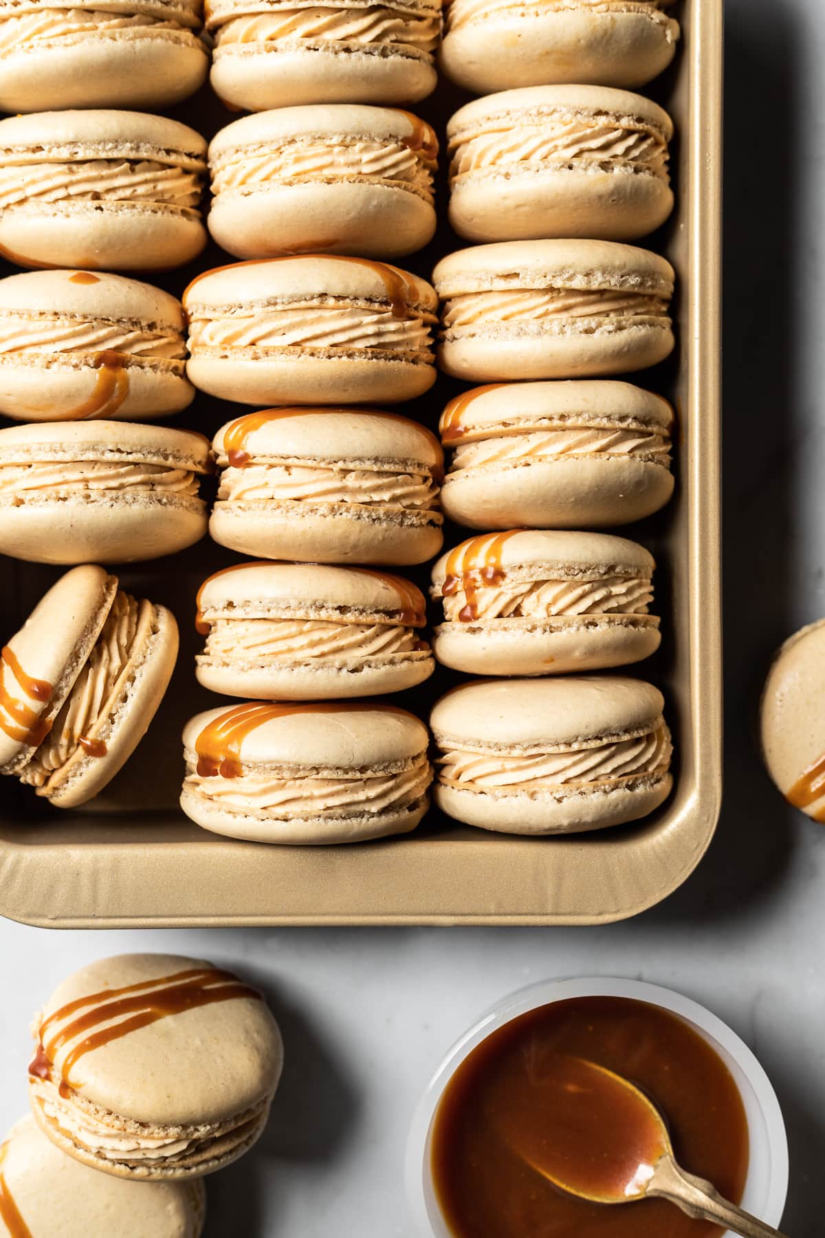 Filled macarons turned on their side to show the piped caramel buttercream.