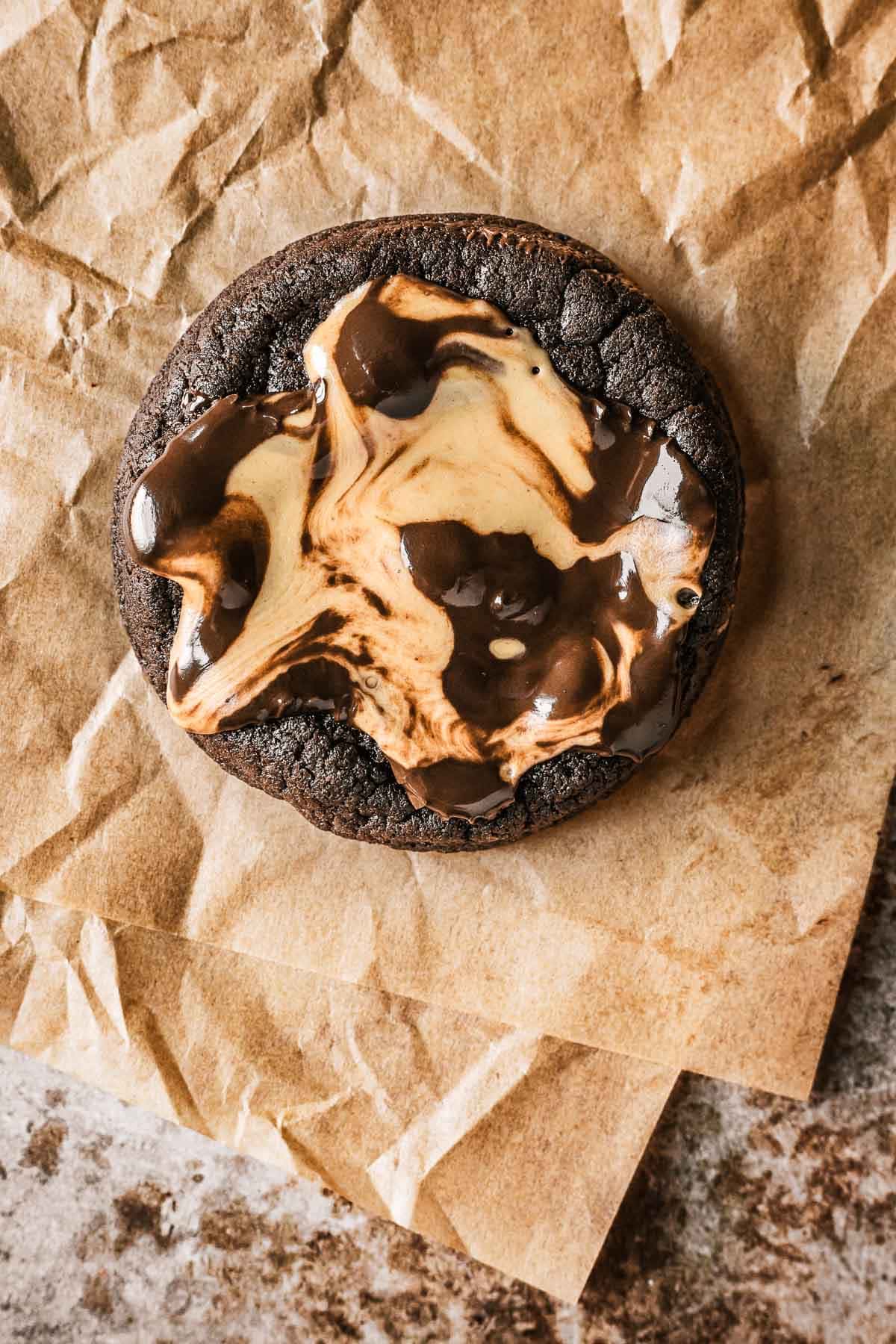 A double chocolate cookie topped with a melted peanut butter cup.