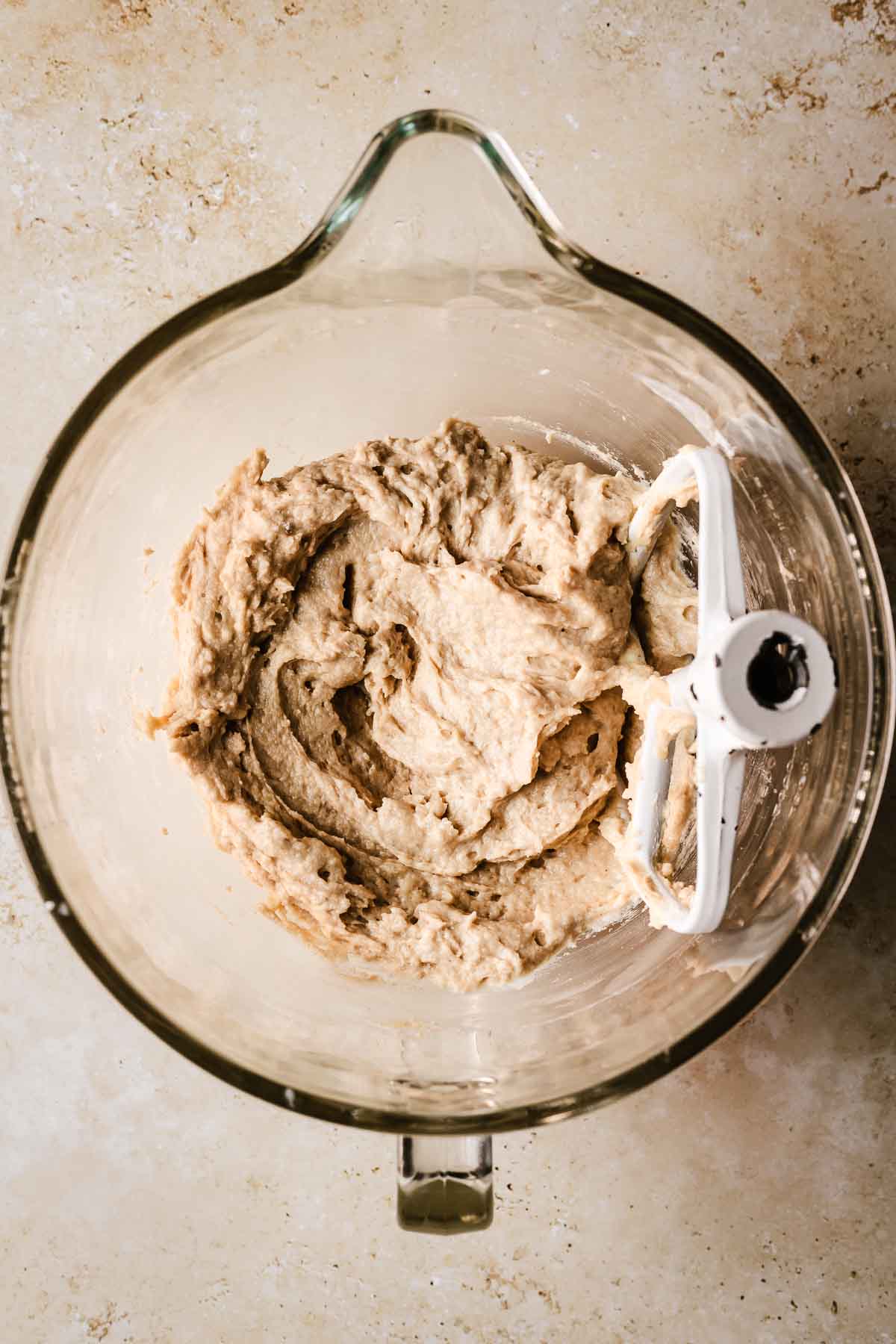 A clear glass bowl filled with finished cinnamon streusel muffin batter.