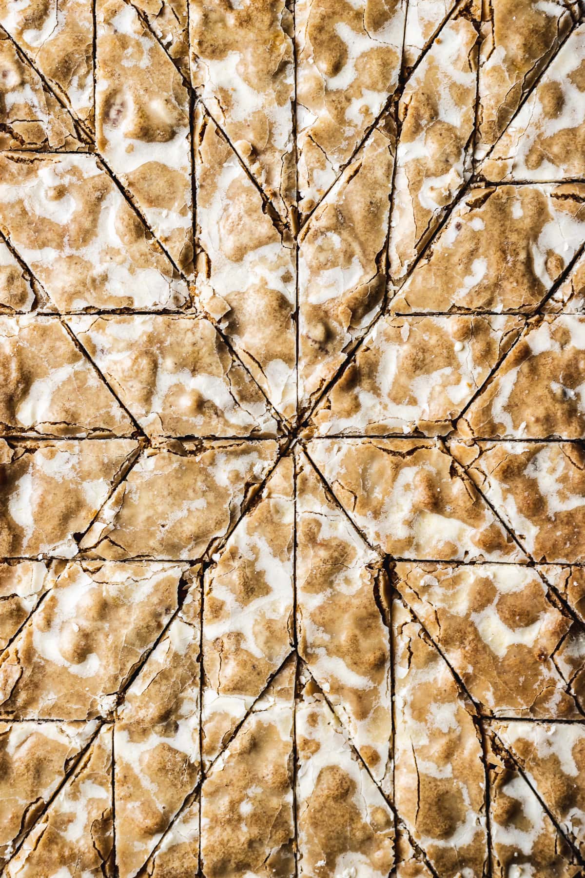 A closeup of spiced and glazed bar cookies cut into a decorative holiday star pattern.