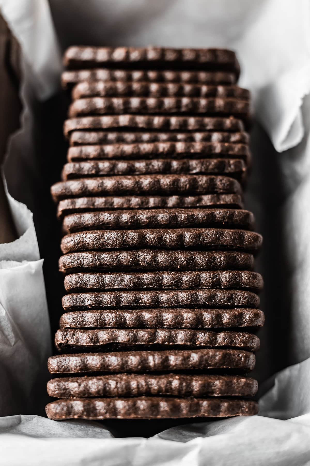 A row of cookies in a parchment paper lined container.
