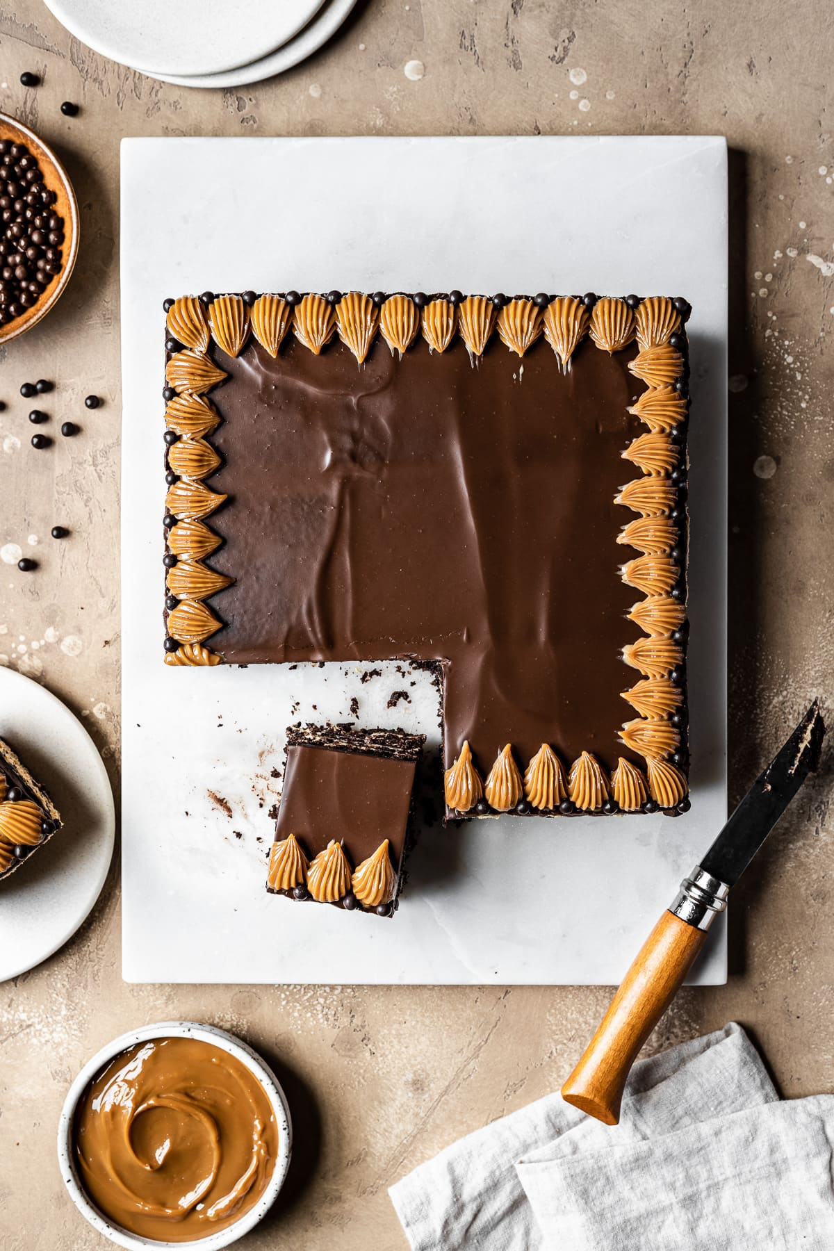 A square chocolate icebox cake with two slices cut out of it. 