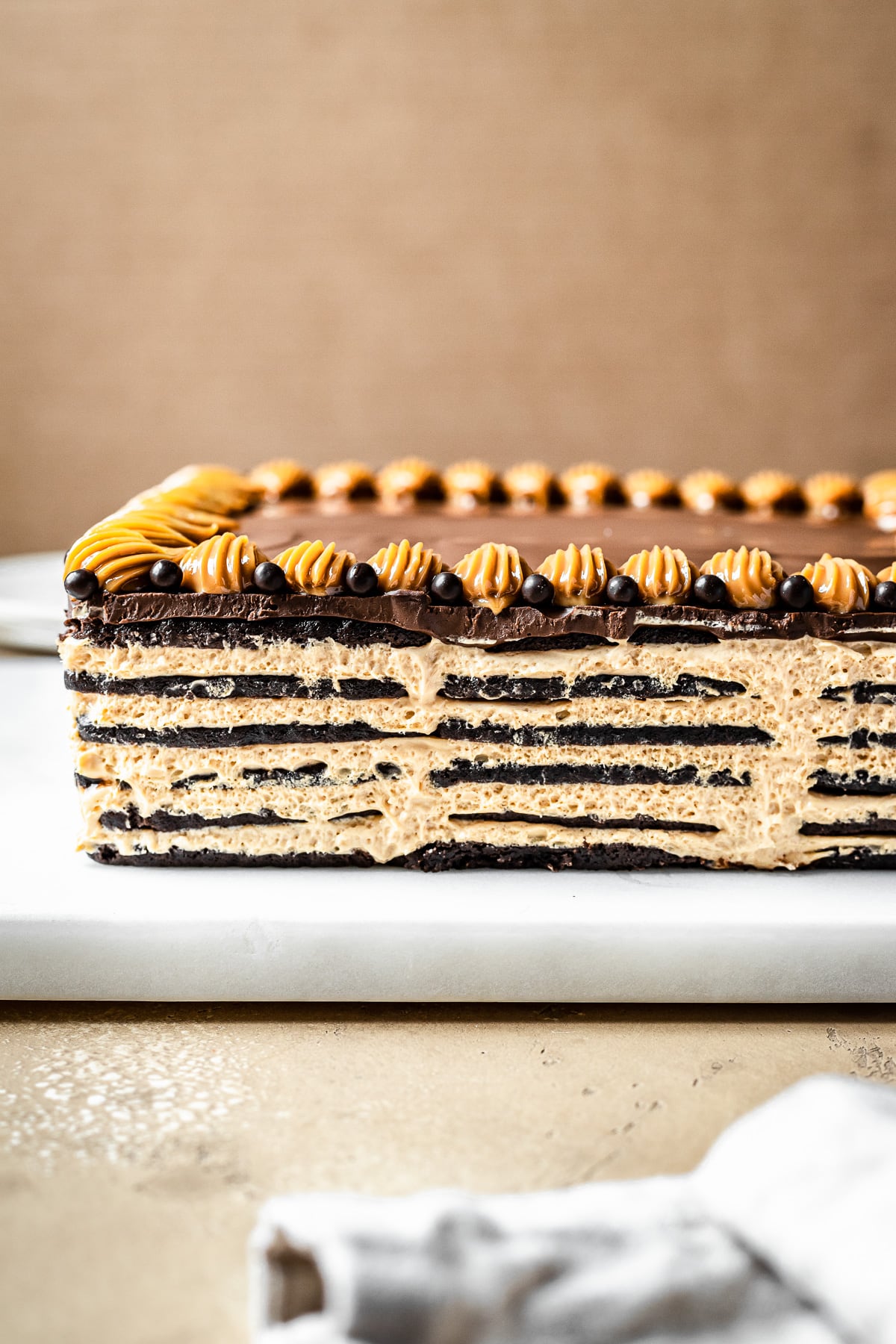 Layers of chocolate wafer cookies and cream cheese filling topped with chocolate ganache.