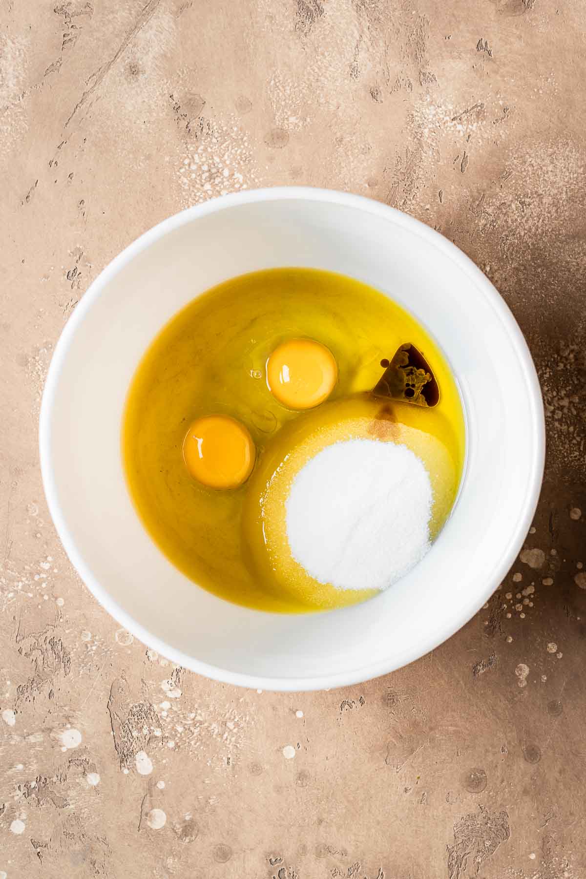 Wet ingredients for yogurt plum cake in a ceramic bowl.