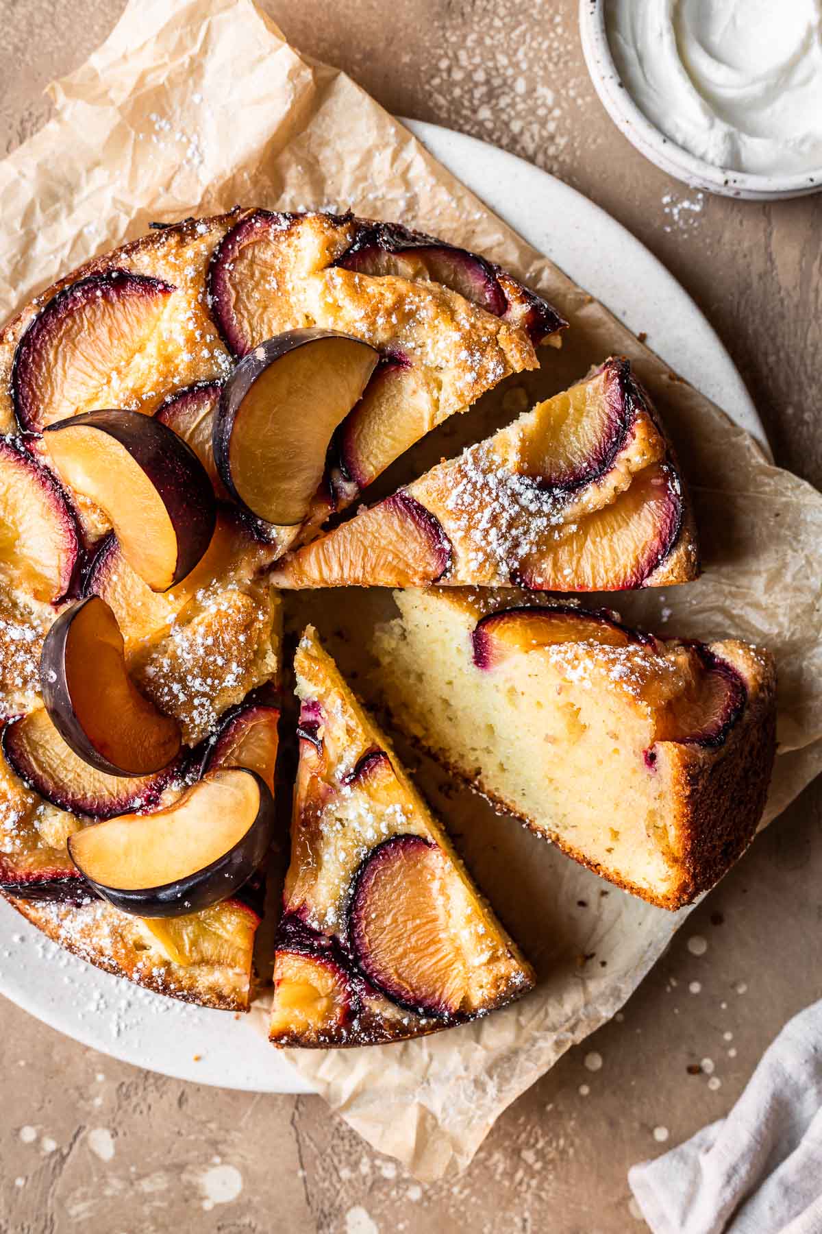 A close up photo of plum cake with several slices cut and turned to the side.