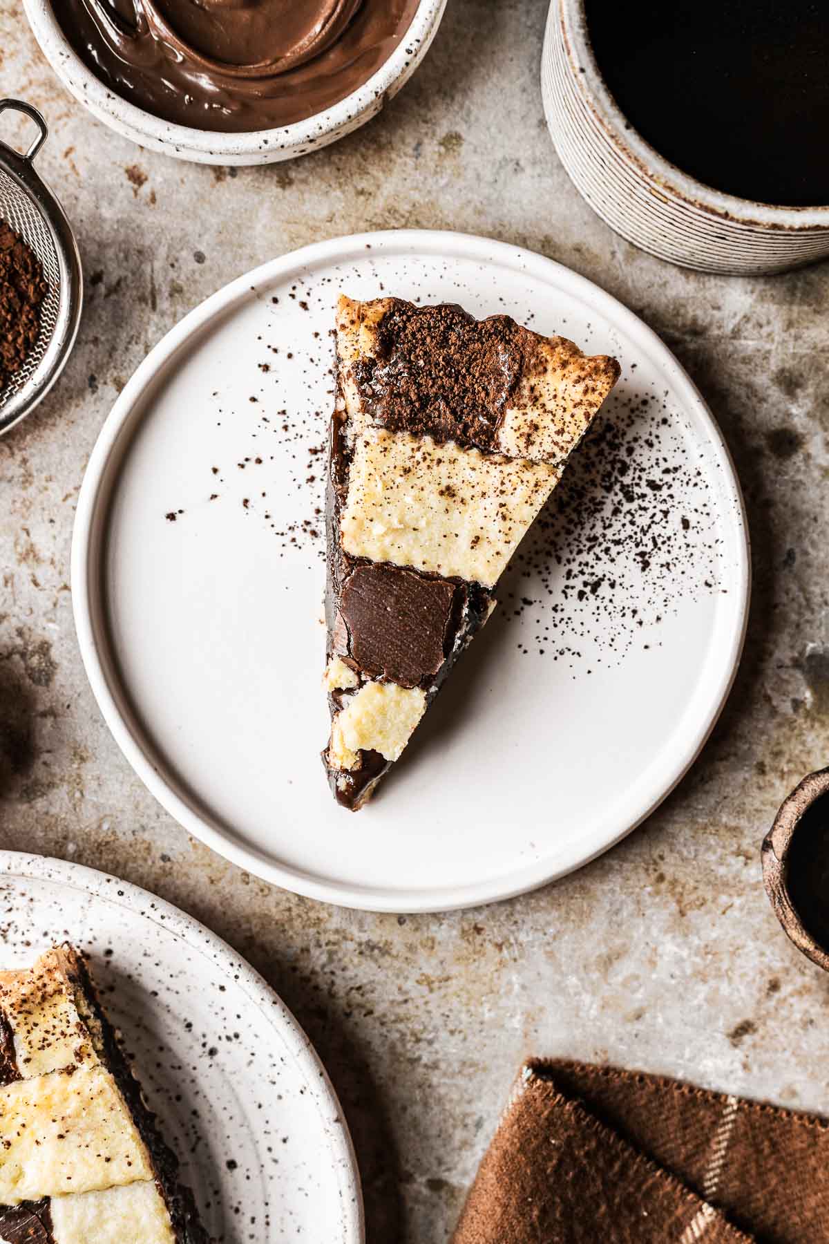 A slice of lattice woven nutella tart on a white plate.