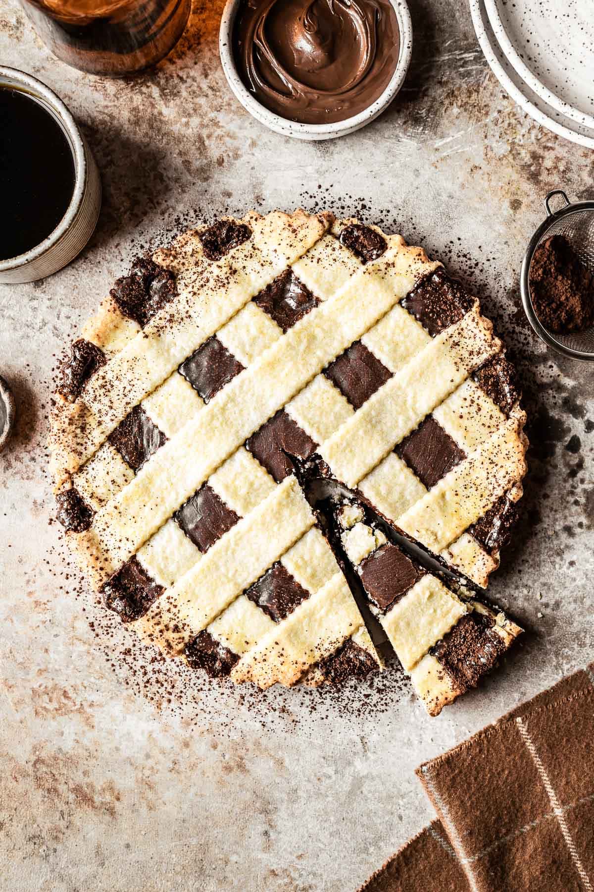 A chocolate hazelnut tart with one slice marked.