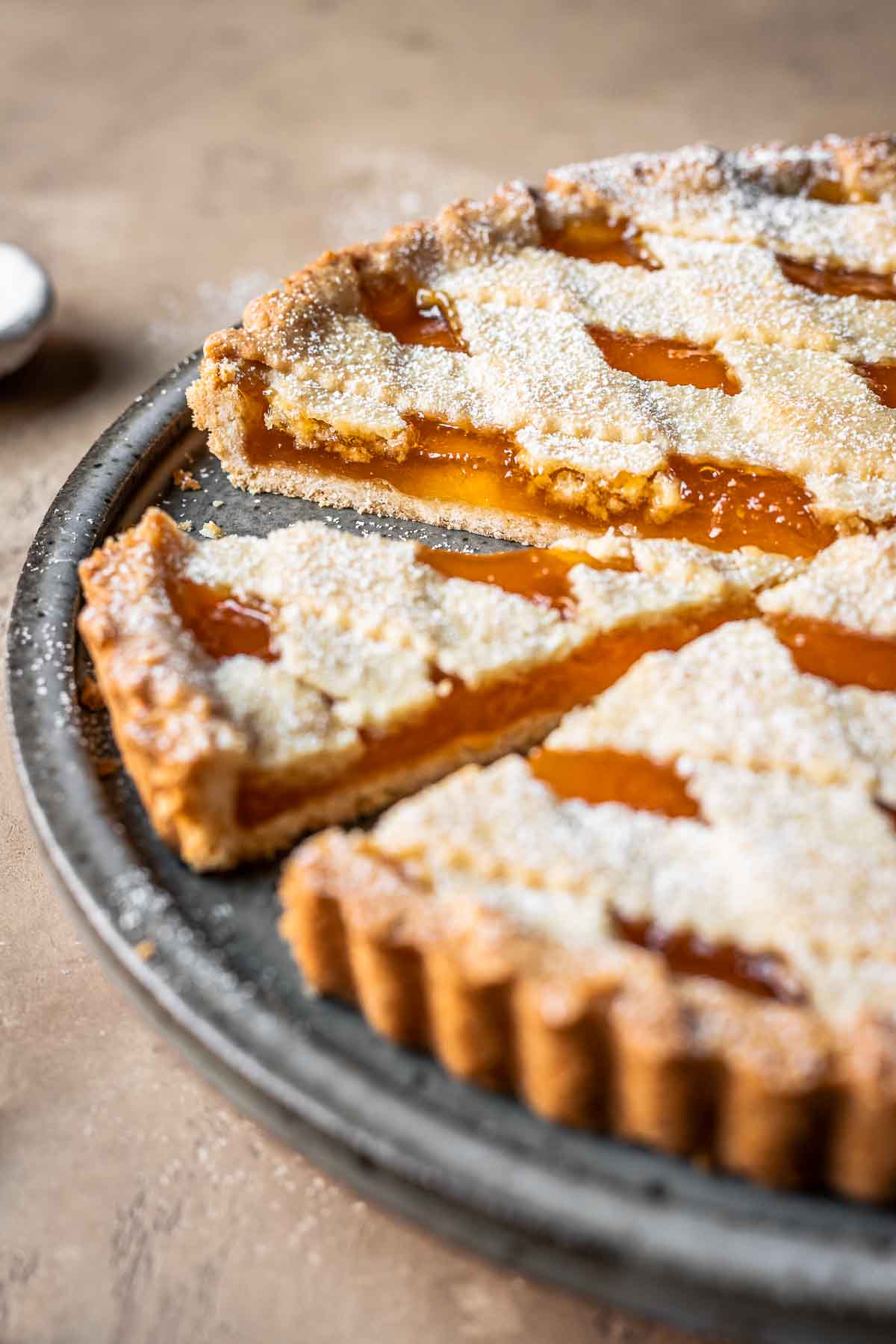 Close up side view of sliced apricot jam tart.