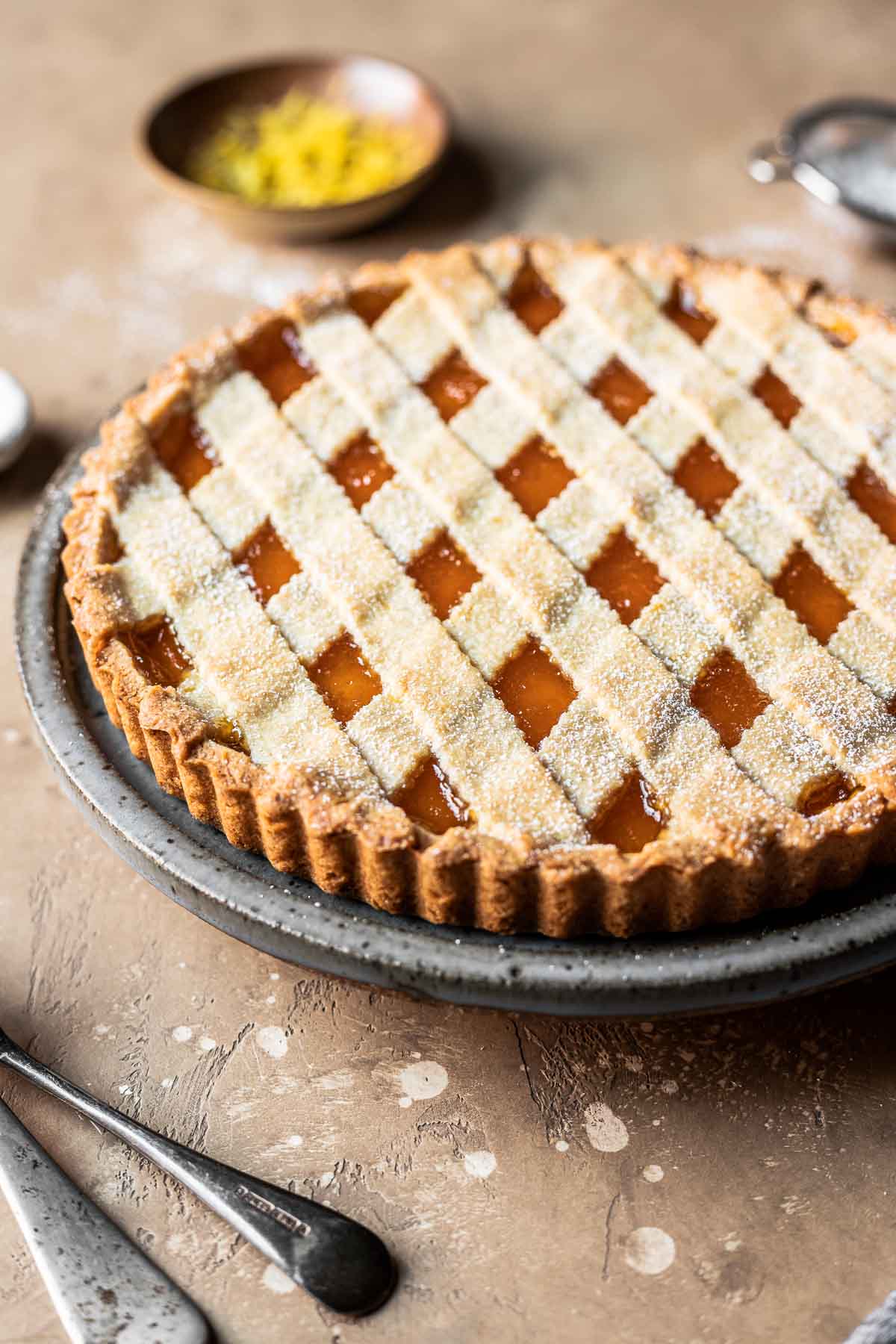 A lattice topped crostata di marmellata on a plate.