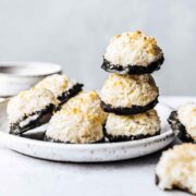 Chocolate dipped german macaroon cookies on a white ceramic plate.