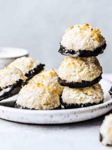 Chocolate dipped german macaroon cookies on a white ceramic plate.