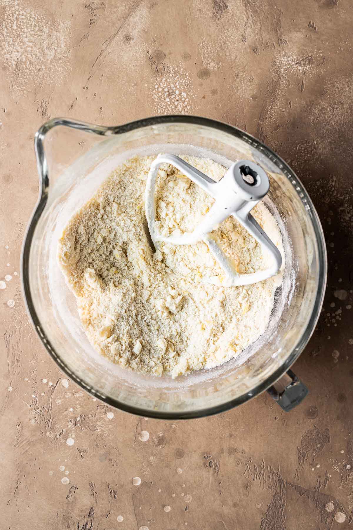 Dry and wet ingredients for tart dough in a clear glass mixing bowl.