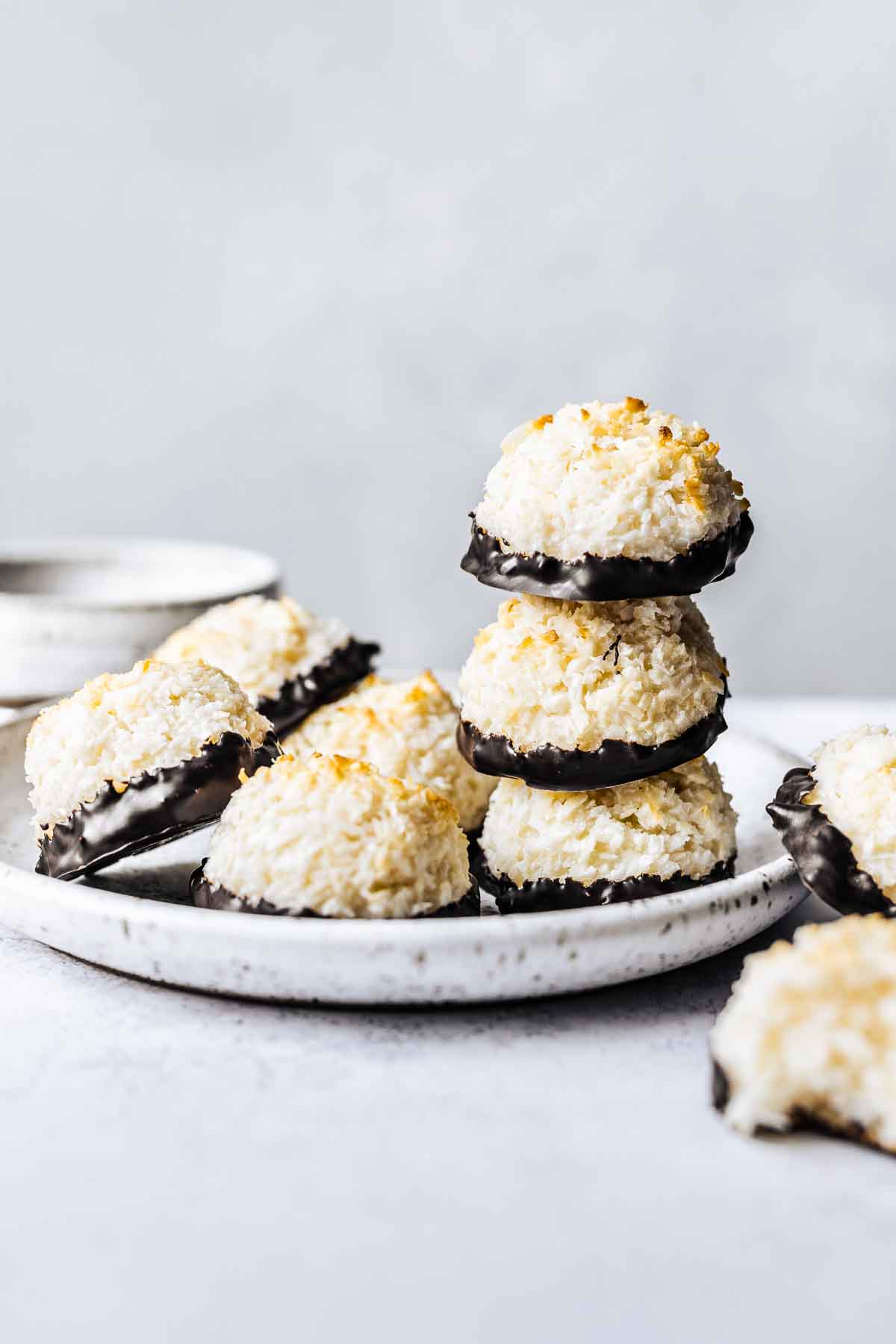 A stack of German kokosmakronen cookies on a white ceramic plate.