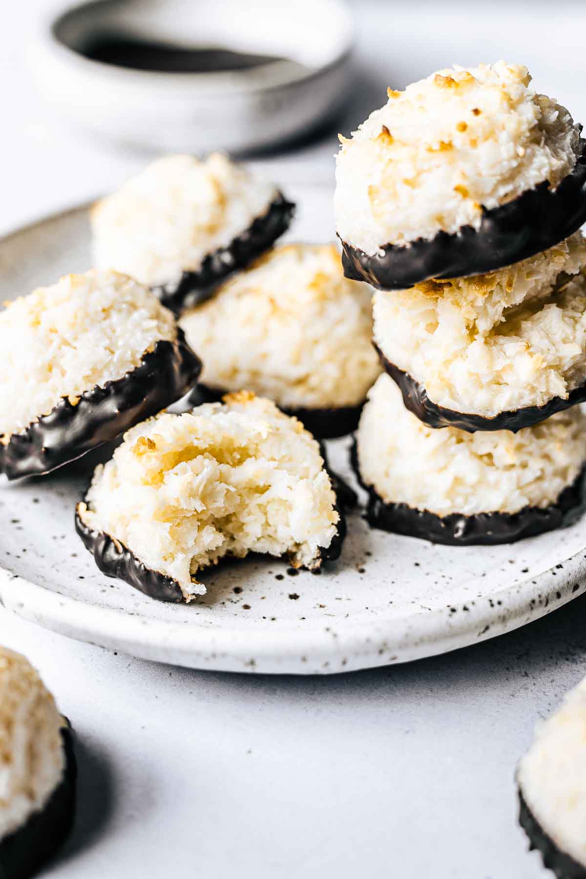 A close up photo of coconut macaroons on a white plate.