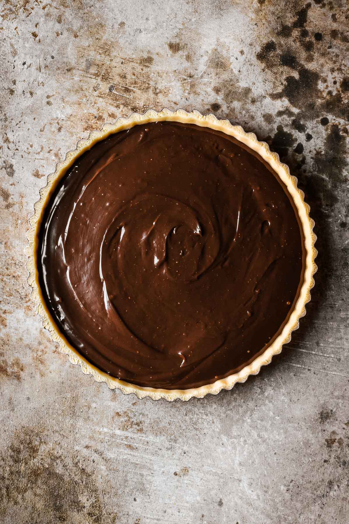 An unbaked tart shell with chocolate hazelnut filling.