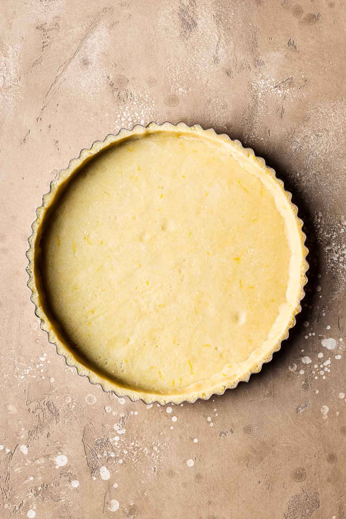 Unbaked pastry dough in a fluted tart pan.