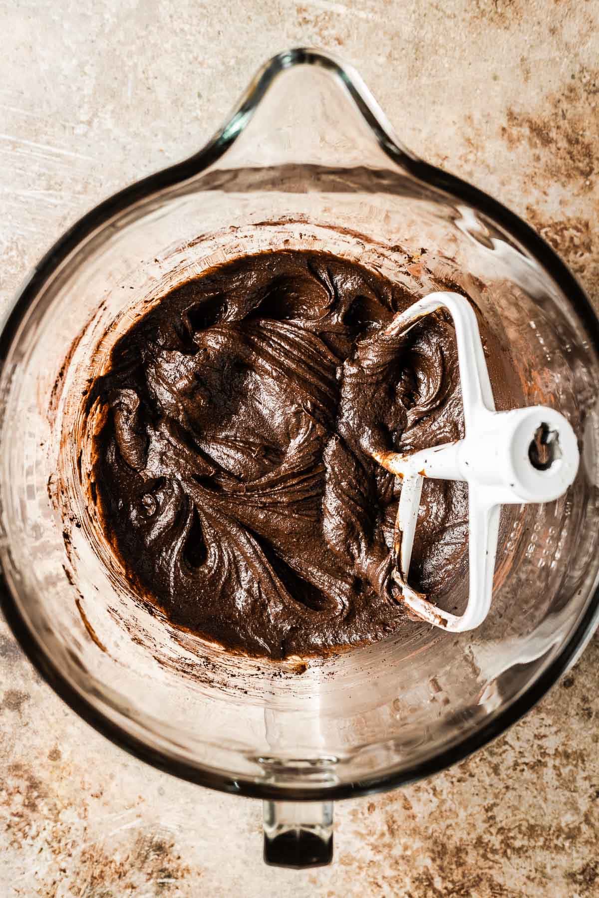 A mixing bowl with cocoa powder mixed into chocolate gingerbread cookie dough.