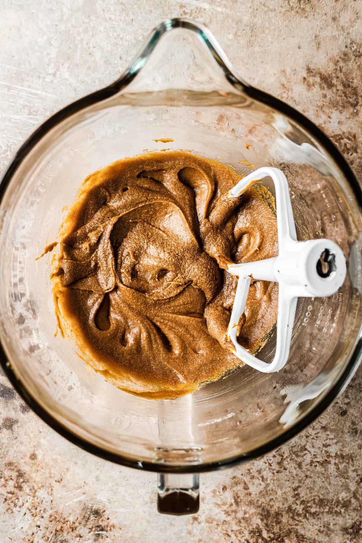 A mixing bowl with wet ingredients added to cookie dough.