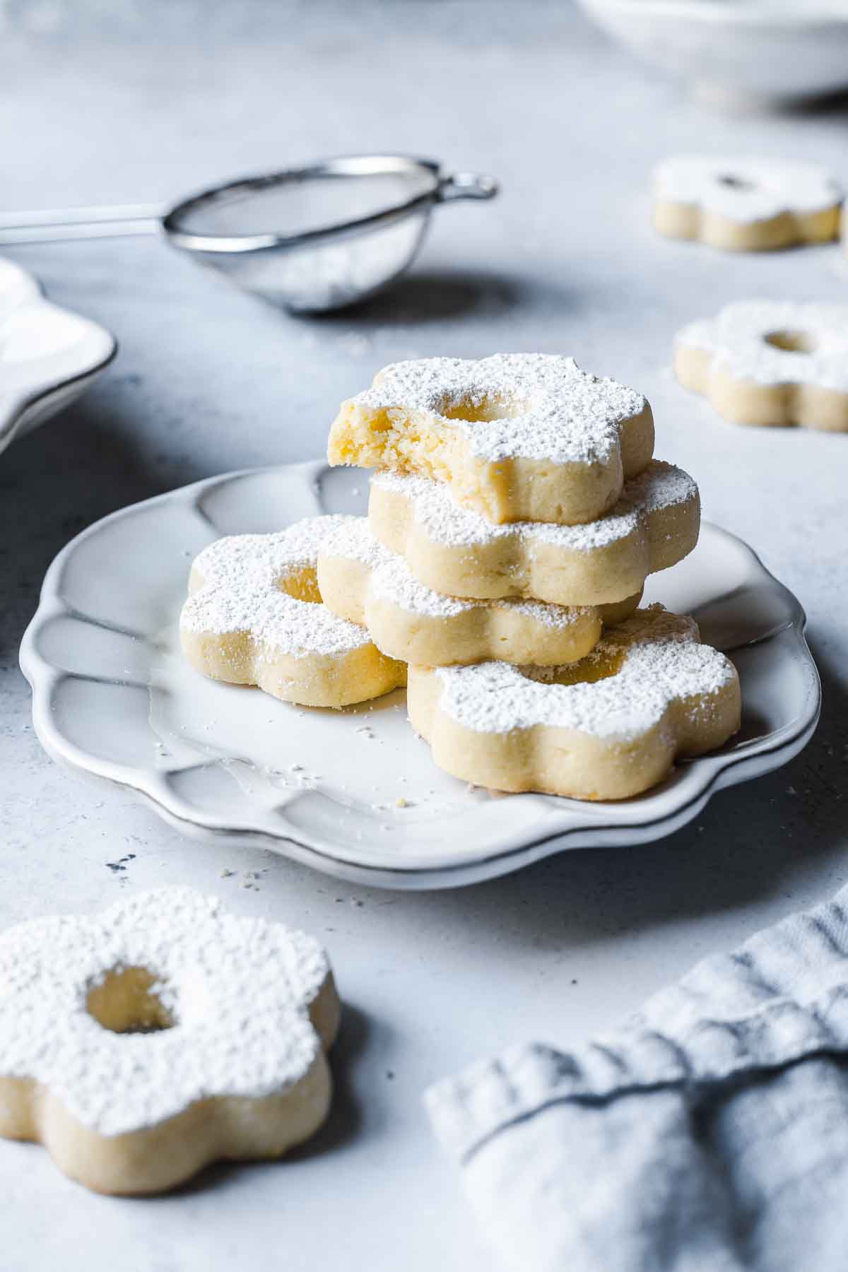 A stack of butter cookies on a white ceramic plate.
