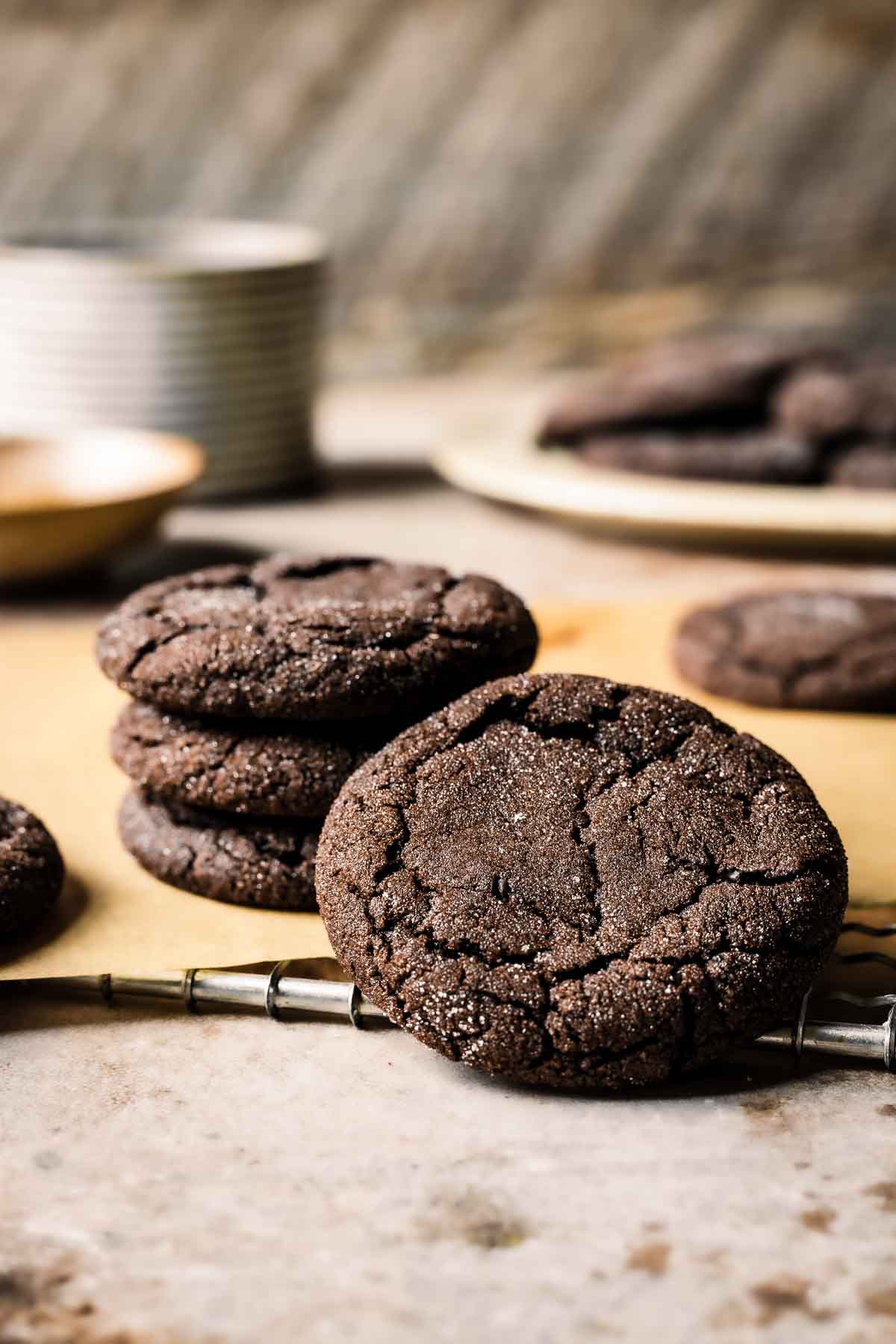 A stack of cookies on a cooling rack with one tipped on its side.