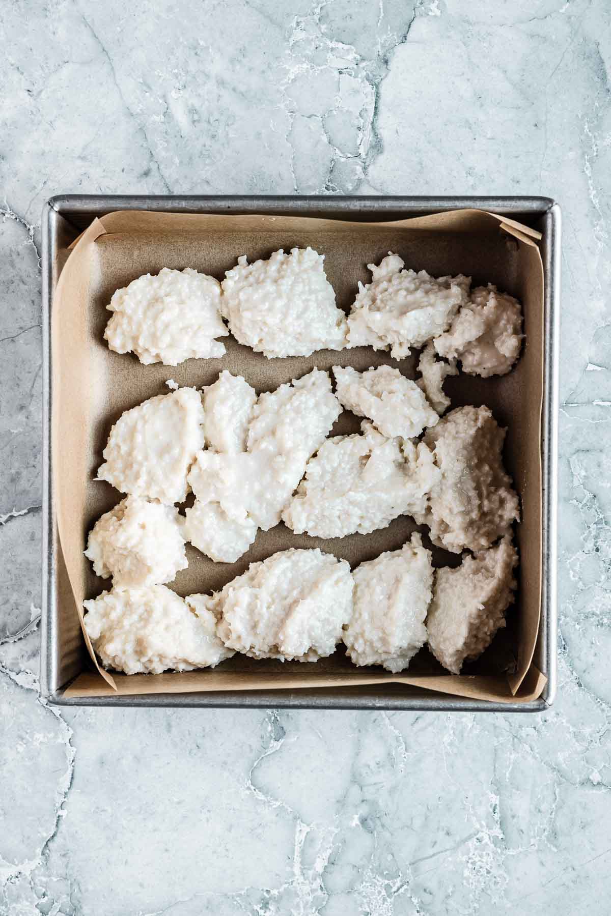 The white layer of coconut ice candy in a square pan.