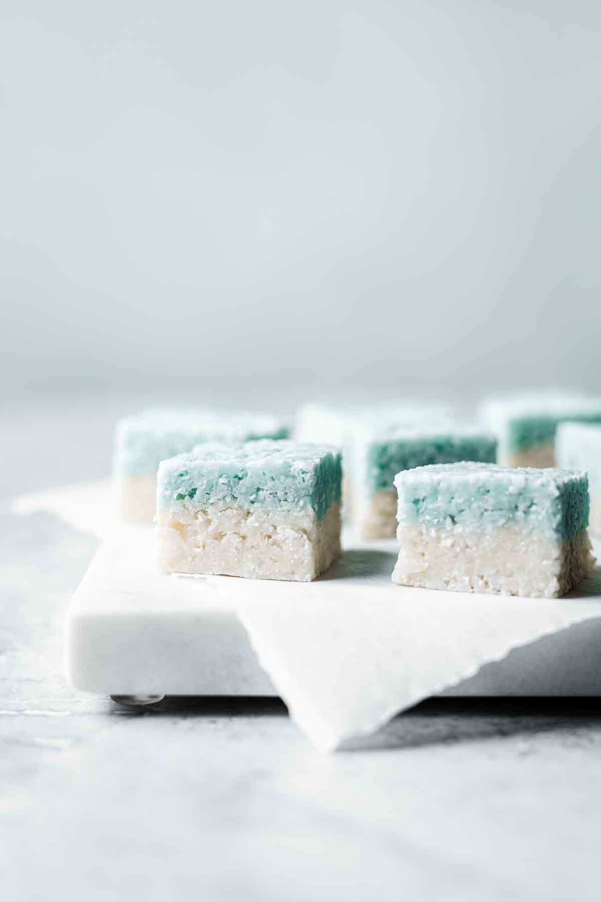 Blue and white layered candy squares on a marble tray.
