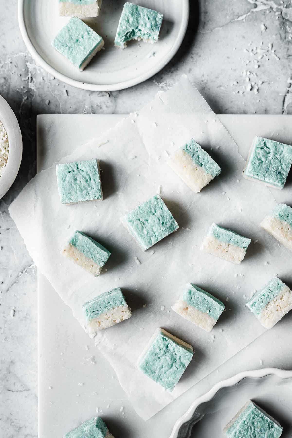 Squares of blue and white candy on a white marble tray.