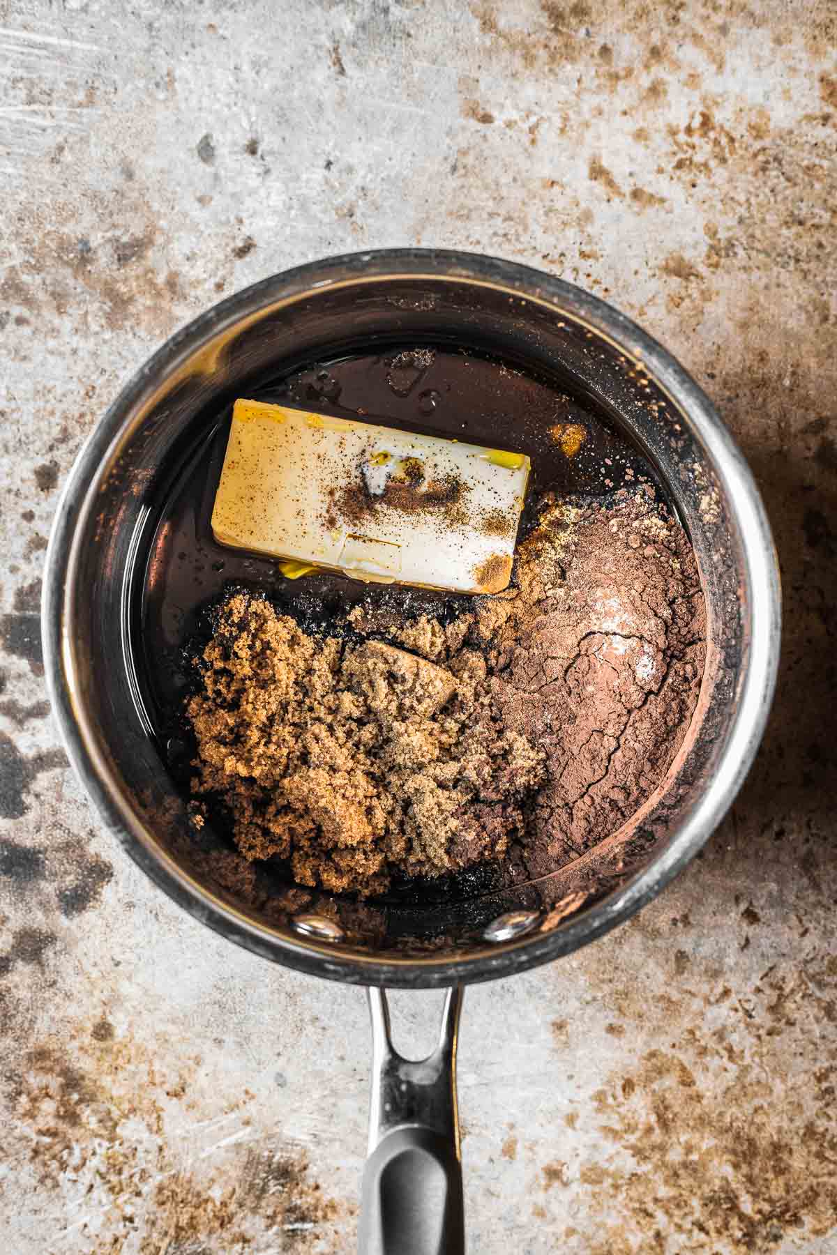 A saucepan with butter, sugars and spices for gingerbread cake.