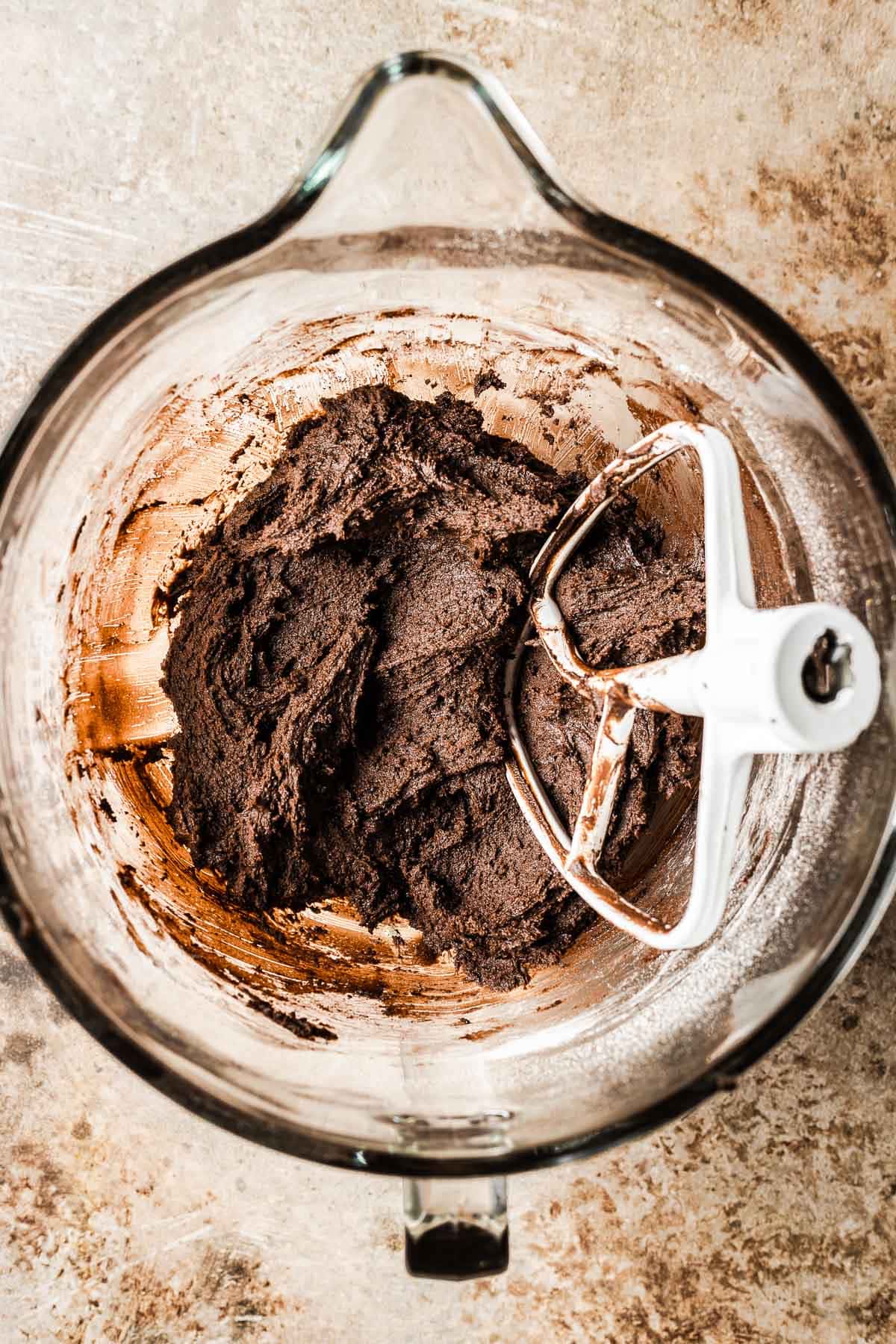 A mixing bowl of finished chocolate gingerbread cookie dough.