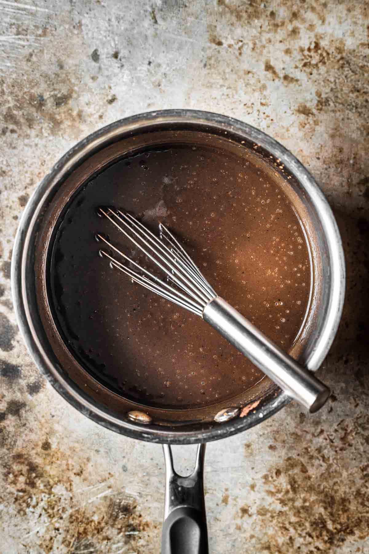 A saucepan with melted butter, sugar and spices for cake batter.