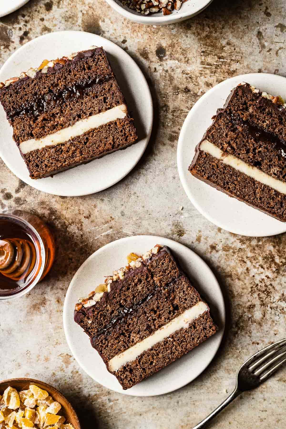 Slices of Polish honey spice cake on tan plates and a brown background.